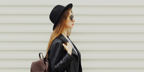 Portrait of stylish young woman wearing a black round hat, jacket on a white background