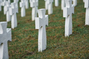 Cemetery with many of white memorial crosses of unnamed people. Conception of death
