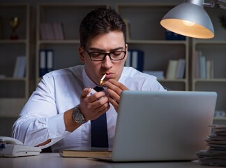 Businessman under stress smoking in office