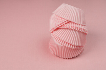 Colorful hot pink paper cups for baking muffins or muffins on pink background, copy space