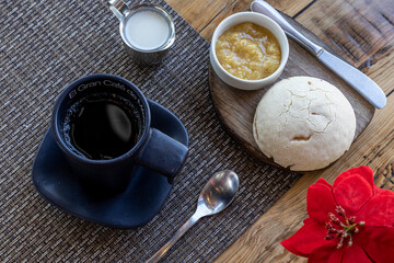 Vista superior de una taza de caf&eacute;, crema y pan con mermelada sobre una mesa