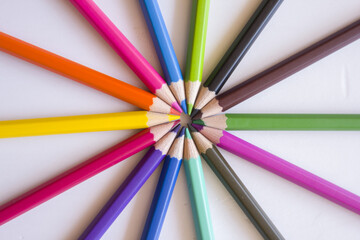 Colored pencils placed in circles on a white background.
