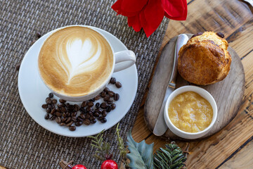 Vista superior de una taza de café capuchino y pan con mermelada sobre una mesa