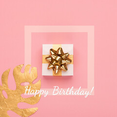 Fototapeta na wymiar Golden tropical leaves Monstera, gift box and Happy Birthday text on pink background.