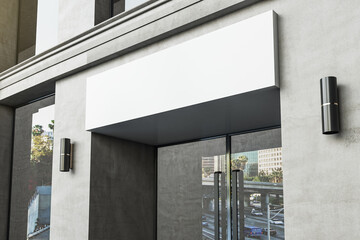 Empty white banner over entrance of modern office building.