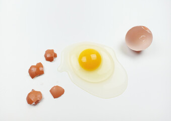 One raw chicken egg with yellow yolk and clear white egg in three layers and broken eggshell in pieces isolated on white background with clipping path. The largest cell in the world.