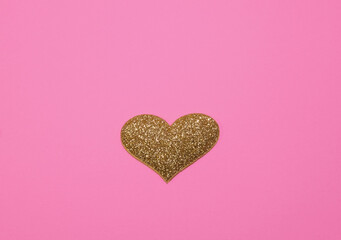 Gold glittering heart for valentine's day isolated on pink background. Glitter and sparkles hearts. Expensive ornate banner. Valentines day background