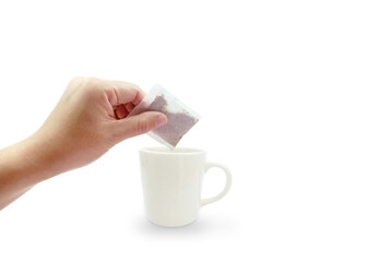 Asian woman hand holding dry tea bag of herb for making tea in white ceramic cup or mug on white background with copy space and clipping path. Herbal tea for healthy concept.