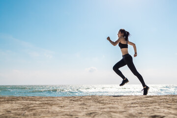 Fototapeta na wymiar Asian healthy sport athlete girl running or jogging on beach in morning