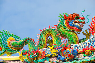 Fototapeta na wymiar Colorful mosaic dragon statue on the roof of a Chinese temple