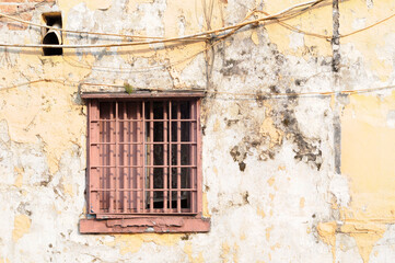 Rustic lattice window in old wall 