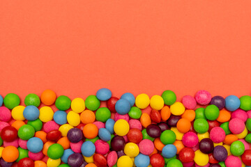 Many colorful candies on red background