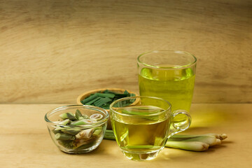 Lemon grass tea in glass and fresh lemon grass sliced and green leaf on wooden background. Healthy...