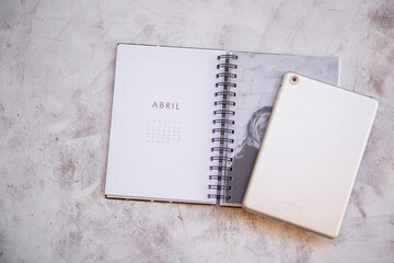 agenda 2021 mes de abril sobre escritorio junto a una tablet