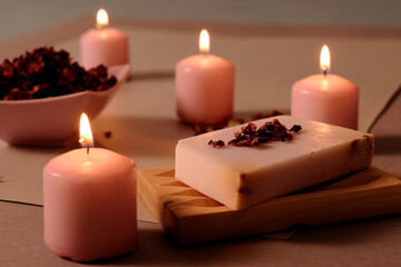 Obraz na płótnie Canvas Romantic bath accessories arrangement with rose handmade soap, pink candles and rose petals.