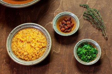 Bowl with red lentil and dried apricot soup with parsley and  apricot for garnish.