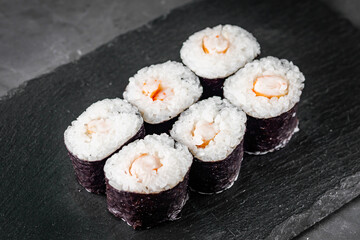 appetizing sushi shrimp maki roll on a black stone plate