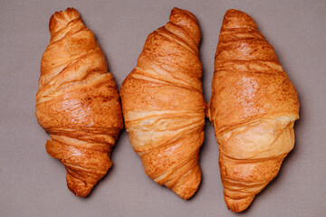 3 croissants on a gray tablecloth