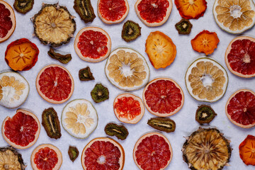 Dried dehydrated fruits on bright background with copy space. Healthy natural flavor snacks: pineapple, persimmon, kiwi and grapefruit chips.