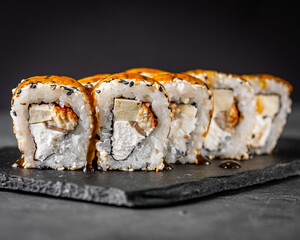appetizing sushi roll california with eel tofu sesame and unagi cheese on a black stone plate