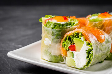 appetizing spring rolls with sea food and philadelphia cheese on a darck background