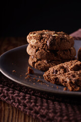 Triple chocolate chip cookies with chunks of white milk and dark chocolate shot with dark creative lighting