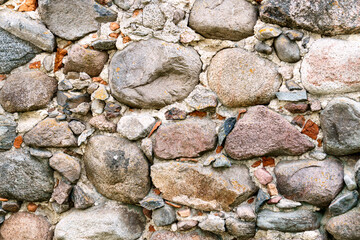 Old masonry wall of large granite cobblestones.