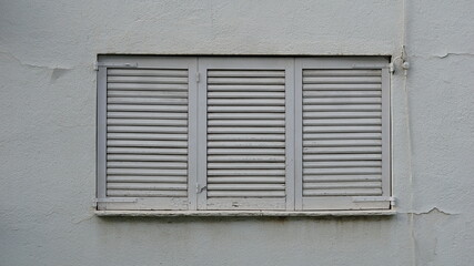 closed window with white wood shutters
