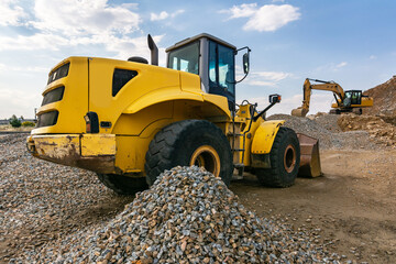 Heavy machinery, excavators at a construction site with stone and rock