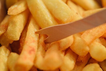 Hot fries with a wooden fork