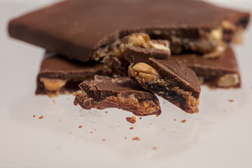 Broken bar of chocolate with nuts and caramel.