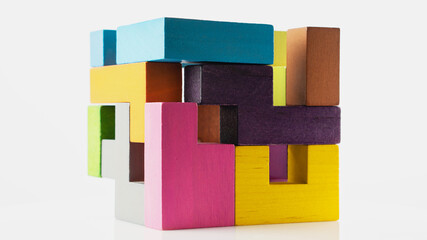 Cube made of multicolored wooden figures on a white background. Concept of logical thinking.