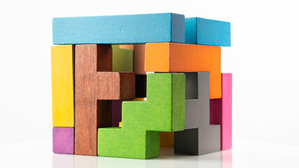 Cube made of multicolored wooden figures on a white background. Concept of logical thinking. - obrazy, fototapety, plakaty