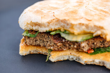 Bitten burger on a black table