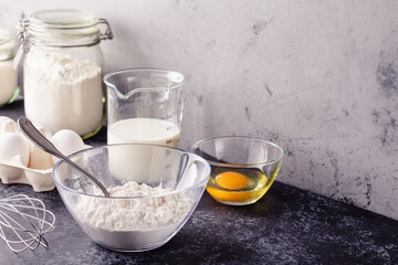 Cooking ingredients for dough, eggs, flour, sugar, milk.