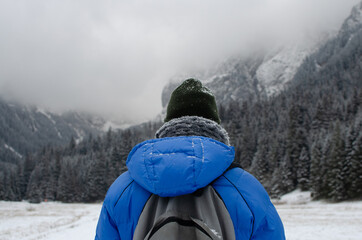 Man hiking with backpack, fogy winter mountains 