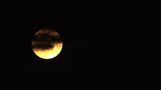 The yellow moon in the night with a black background