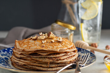 buckwheat pancakes with honey and hazelnuts on an old plate