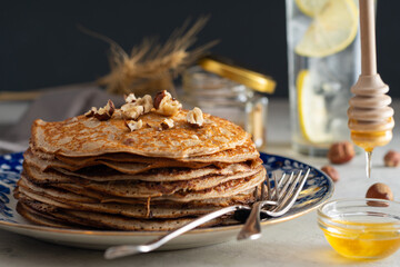 buckwheat pancakes with honey and hazelnuts on an old plate