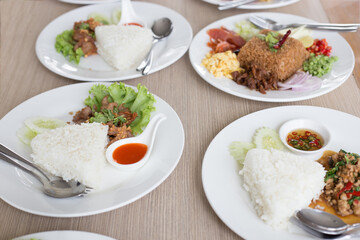 Many Thai food on white plates ready for eating
