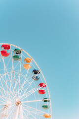 Ferris wheel booths on a blue sky background on a sunny day. Colorful bright cabin of the Ferris...