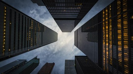 Business and finance concept, moody time lapse view looking up at modern high rise office buildings at dusk in the financial district of Toronto, Ontario, Canada, zoom out. - Powered by Adobe