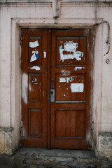 Old door, sealed with signs, of an old-fashioned 19th century house in the historic district of the city