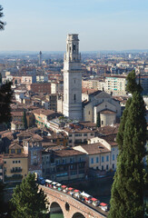 Top view of the old church with a bell tower and a bridge with shopping stalls over the Adige river in Verona.