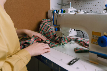 Closeup of a woman working with sewing machine in her workshop