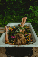 Woman in flower outdoor bath drinking lemonade