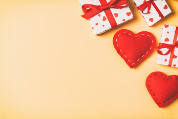 Top view colorful valentine background made of gift boxes and red textile hearts. Valentine's Day concept with copy space