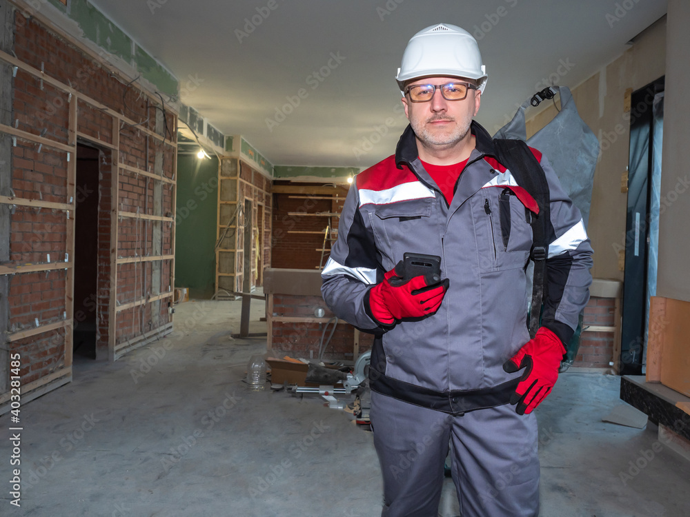 Poster the builder smiles and looks at the camera. civil engineer in a building under construction. archite