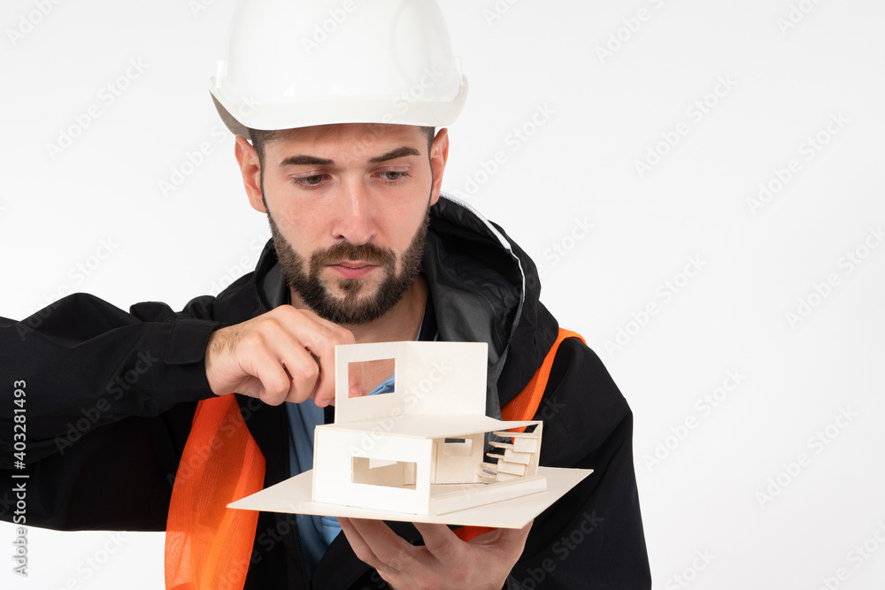 Poster male architect with a layout of the house in his hands. construction engineer in a hard hat. an engi