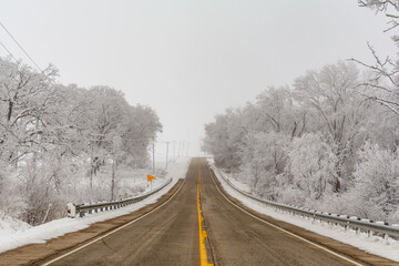 Fototapeta premium Illinois Rt 178 surrounded by snow and ice on a cold and foggy winters day.